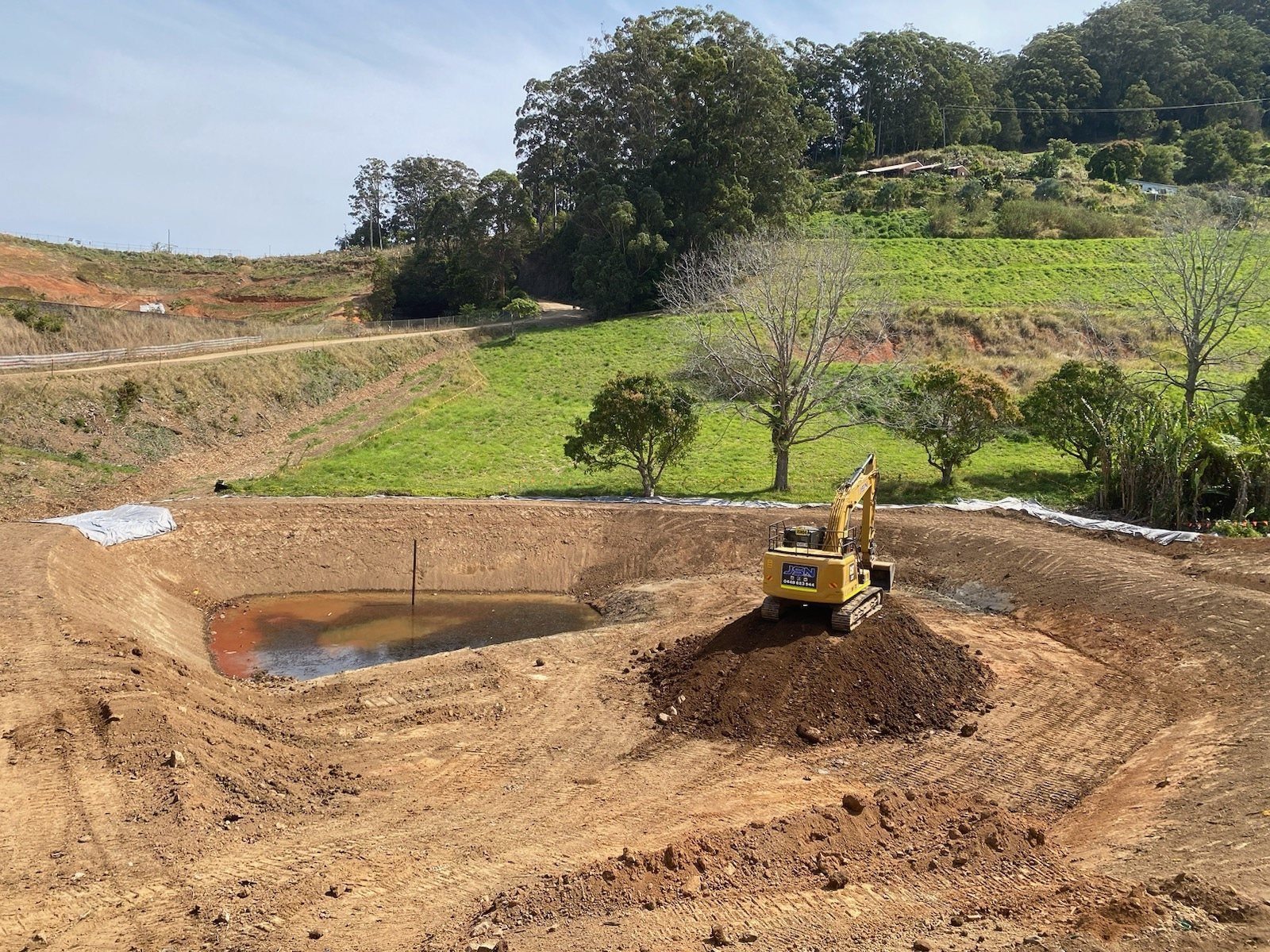 Excavator shaping a basin on a civil project