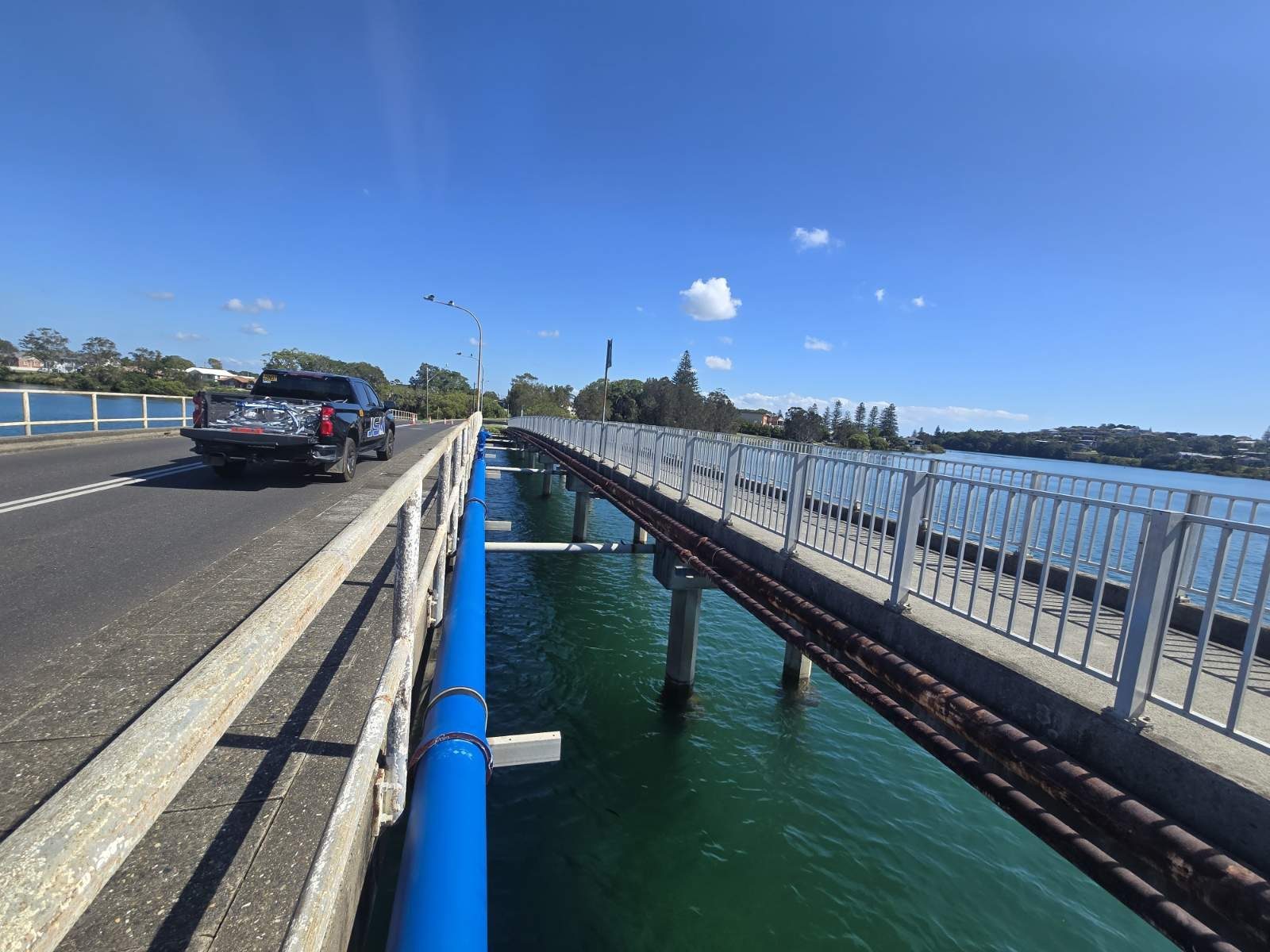 Pipe installation along a bridge over water