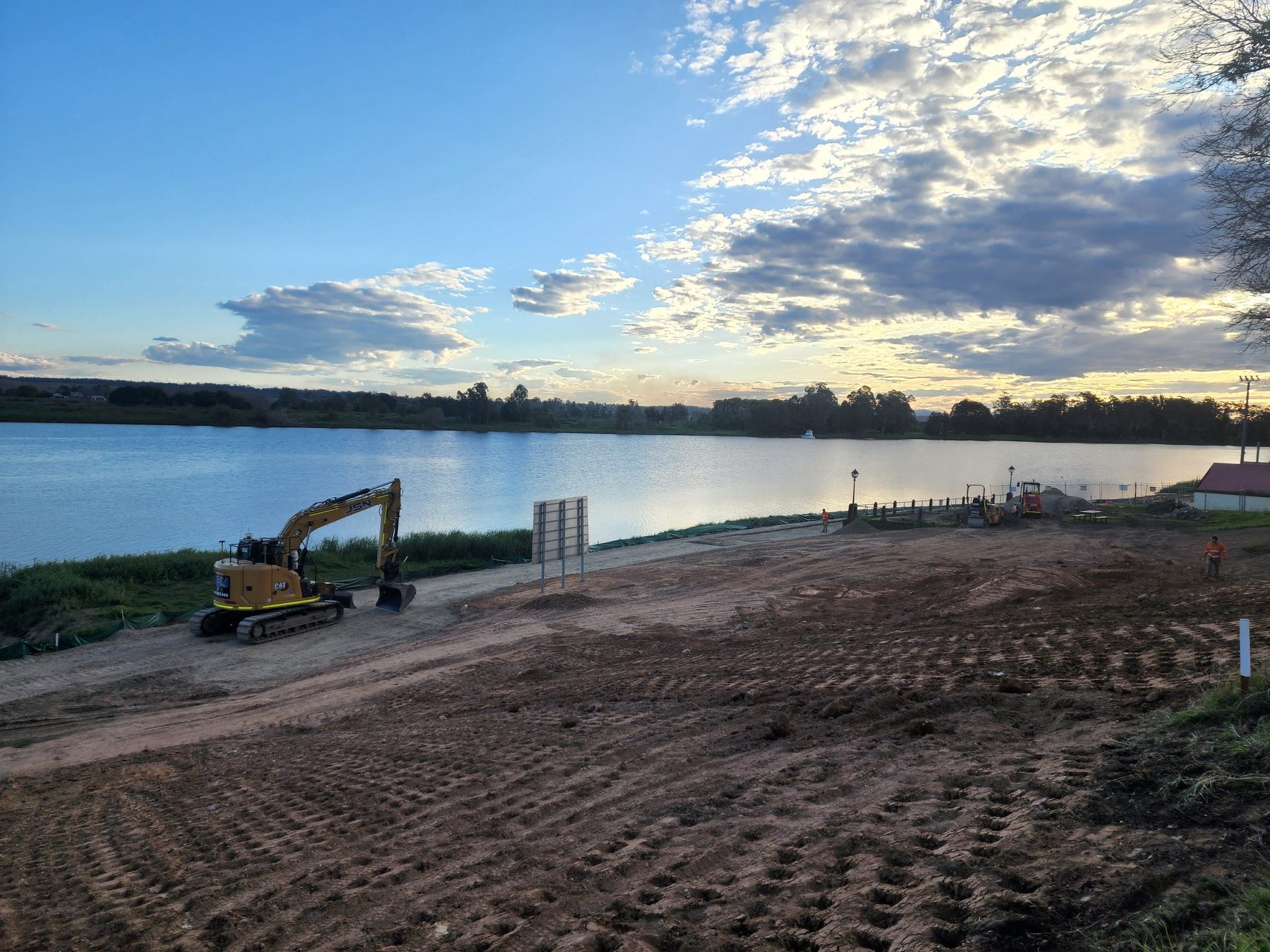 Civil works beside a lake at sunset