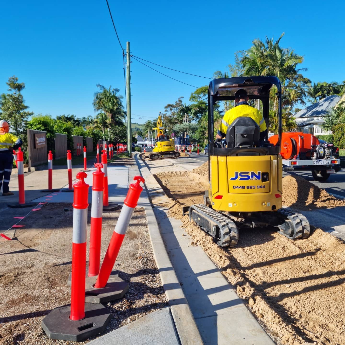 Mini excavator working on a controlled roadside project
